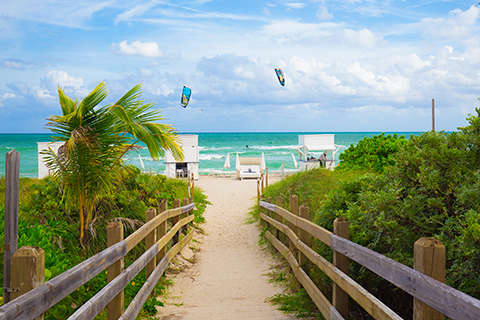 This is a stock photo. A pathway on to Miami Beach with the ocean in the background.