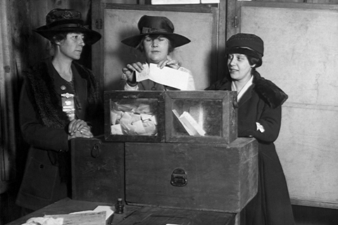A historical 1917 photo of three women suffragists casting their vote at a ballot box. This image was obtained via Shutterstock.